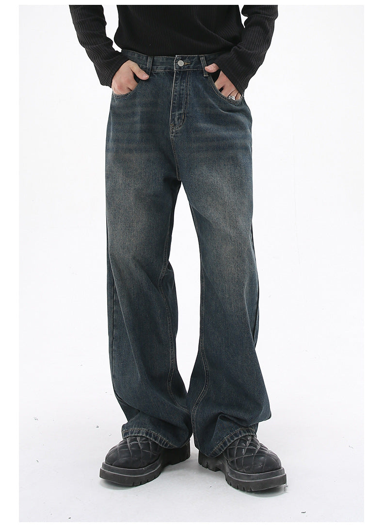 A model is posing in dark-wash wide-leg jeans with hands in pockets, paired with a black ribbed sweater and black platform shoes