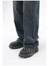 A close-up of the hem of dark-wash wide-leg jeans, slightly pooling over black quilted platform shoes