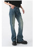 Model with hand in pocket wearing vintage-wash straight-leg jeans with black tee and silver accessories against white background
