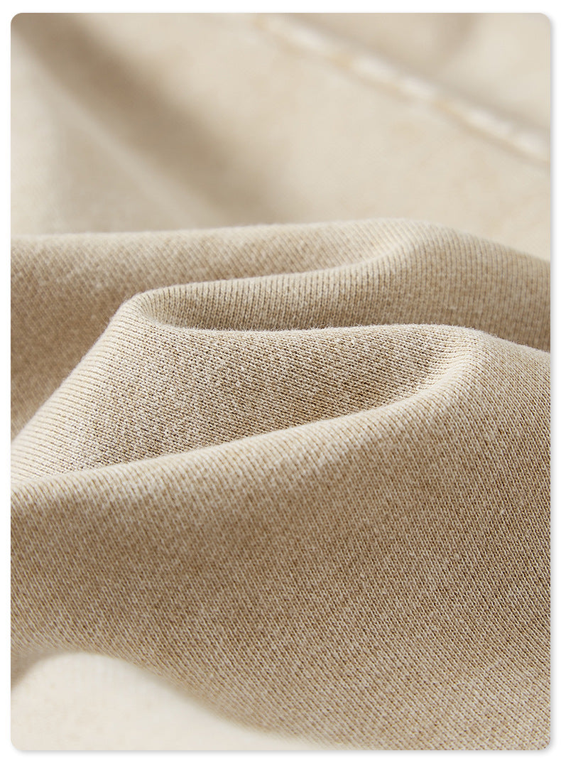 A close-up of soft beige fabric with a subtle texture and natural folds