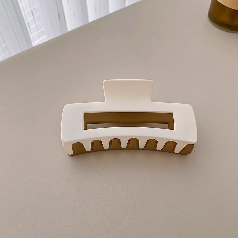 Two-tone white and brown rectangular hair clip with textured teeth, providing sturdy hair support
