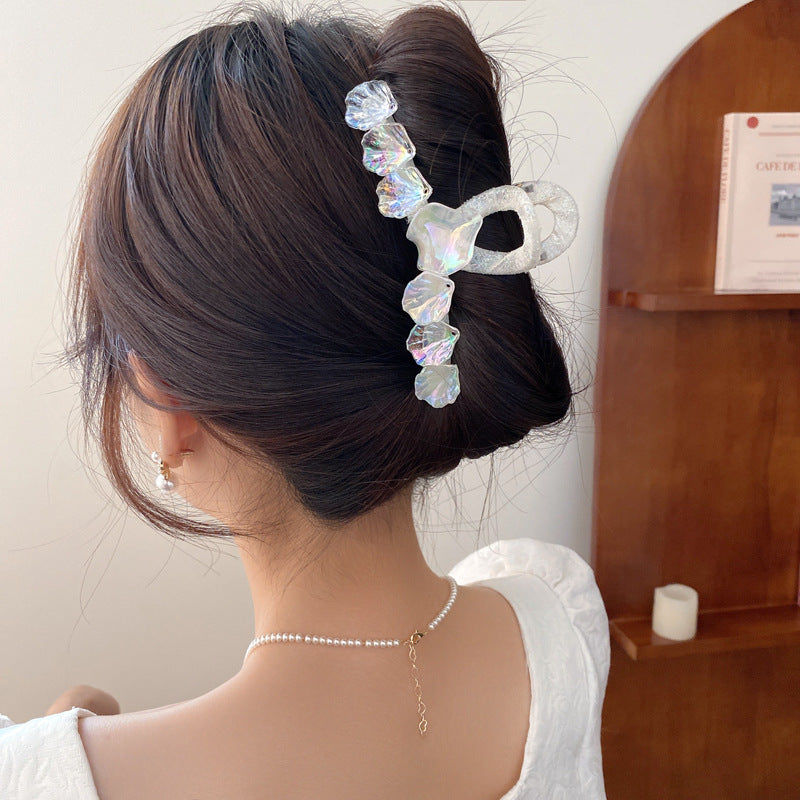 Iridescent shell-inspired hair clip with crystal details, adding elegant and whimsical touch to updo hairstyles