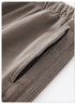 Detail of grey sweatpants fabric showing texture and stitched hem