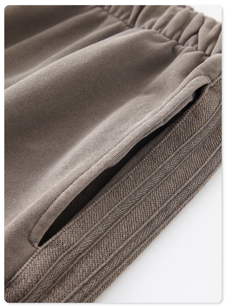 Detail of grey sweatpants fabric showing texture and stitched hem