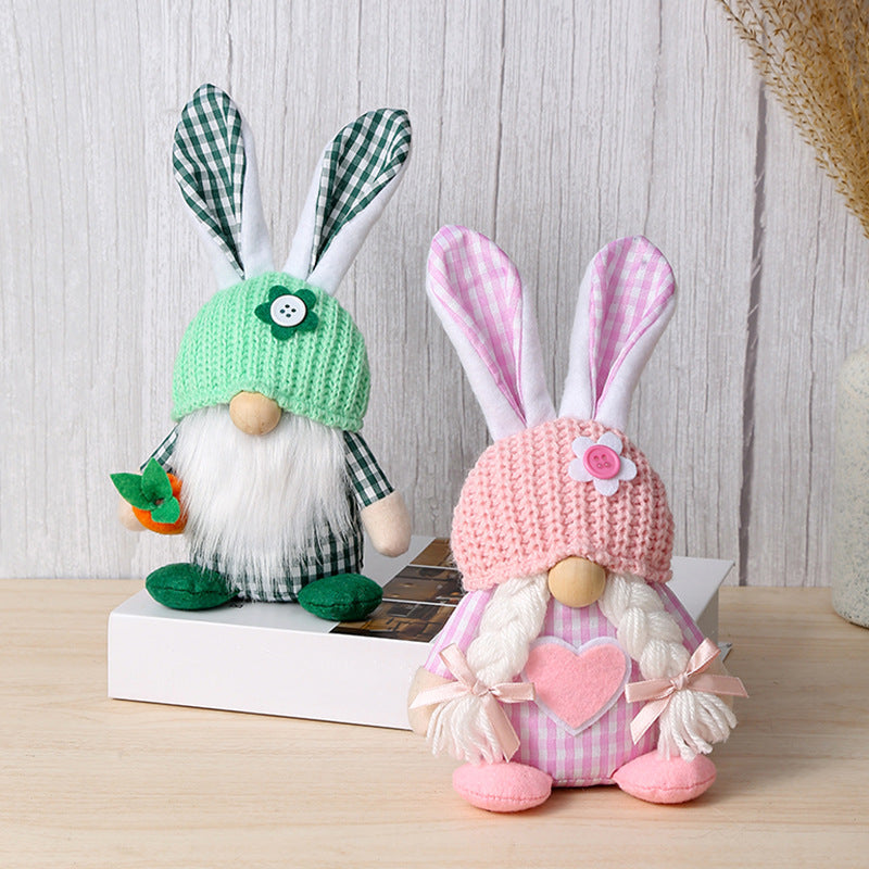 Matching green and pink bunny gnome plush toys with long ears and soft fabric outfits, placed on a book.