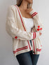 Cream cardigan with red stripes and star accents, layered over white tank for sporty-chic outfit