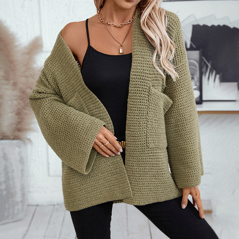 Casual styling of olive knit cardigan with black camisole and statement necklaces, showcasing slouchy silhouette