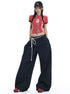 Model standing in dark denim wide-leg jeans, red crop top, and rope waist detail.