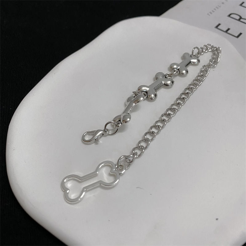 Silver dog bone bracelet laid flat on white background