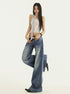 Angled front view of low rise flared jeans in dark blue denim, styled with belt