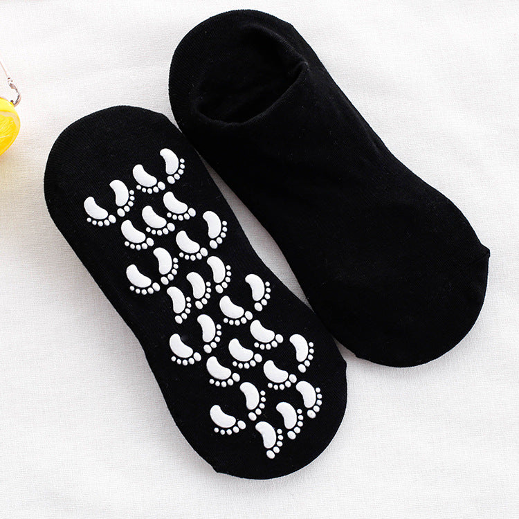 Pair of black ankle socks with white footprint grip pattern, one showing sole design and one showing top side against white background