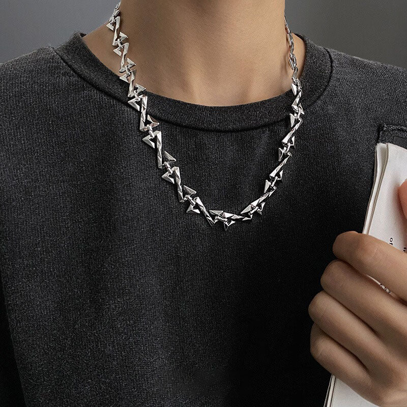 Silver geometric necklace worn with dark gray top