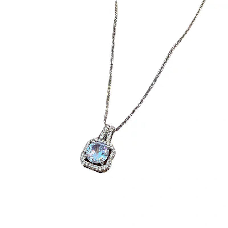Close-up product shot of blue crystal pendant with cubic zirconia halo and silver chain against white background