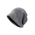 Side view of gray beanie, displaying slouchy style and small metallic logo