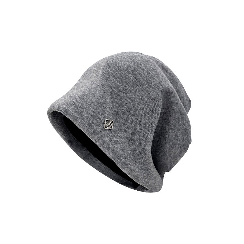 Side view of gray beanie, displaying slouchy style and small metallic logo