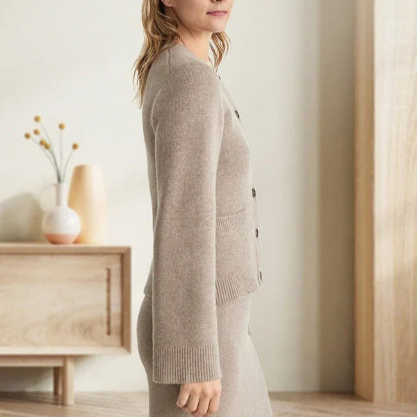Beige knit cardigan, model shown from side view in minimalist interior setting