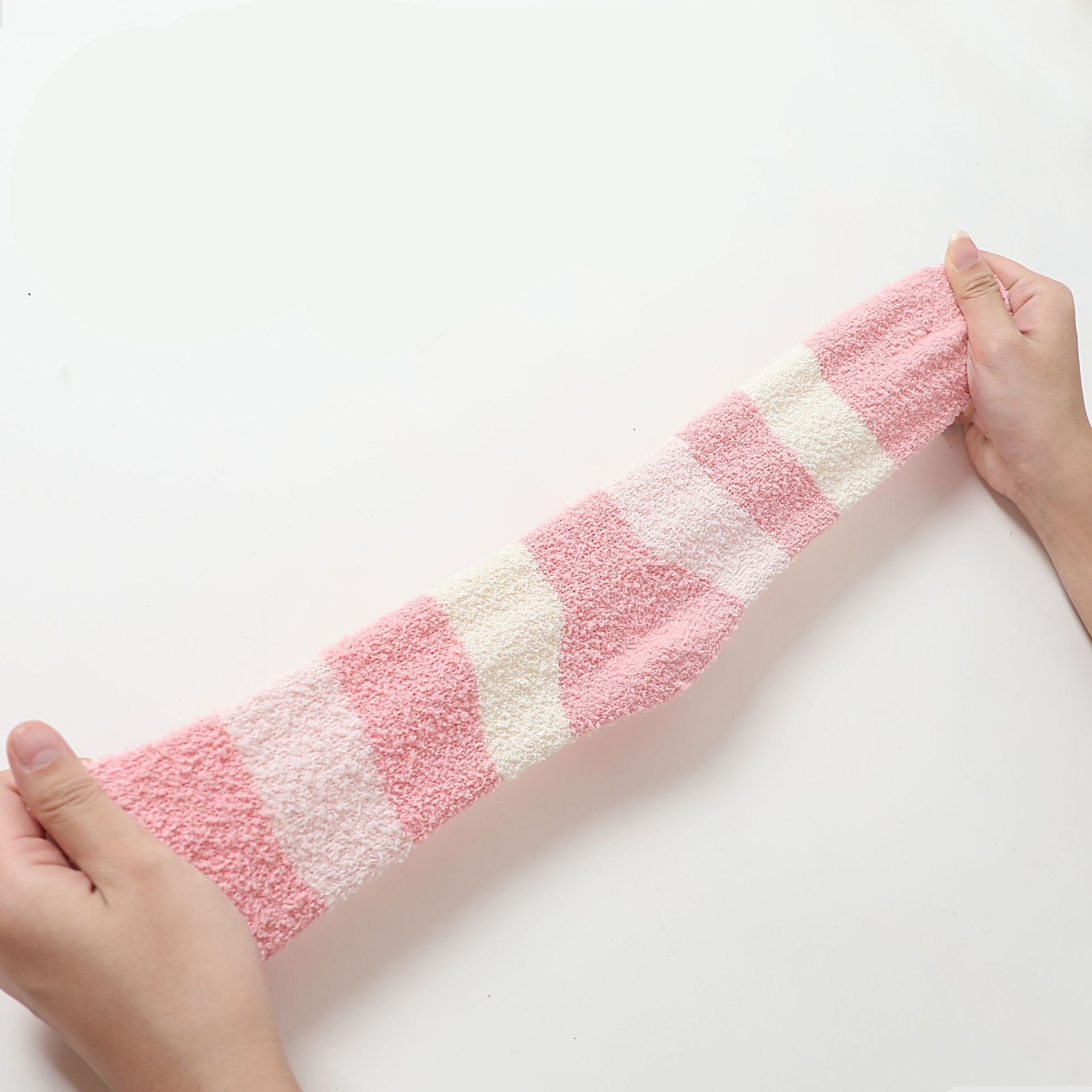 Stretched view of pink and white fuzzy sock material showing diagonal pattern
