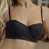 Close-up of black lace bra with delicate lace details – A balconette lace bra with floral embroidery and scalloped trim