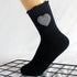 Black crew sock with gingham heart patch shown on a mannequin foot against grid background