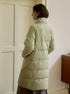 Back view of pale sage green puffer coat showing quilted pattern and length, styled with grey skirt