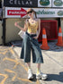 Front angle, hand-in-pocket shot – Retro-style denim shorts with knee crop and street-style edge.