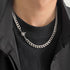 Close-up of Cuban chain necklace showing detailed view of starburst charm with crystal center against black clothing