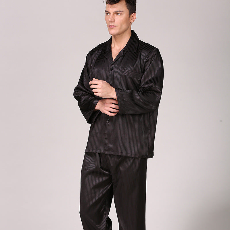 Model standing in black striped silk pajama set with collared shirt, chest pocket and full-length pants