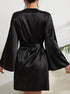 Back view of black silk robe showing bell sleeves and tied waist belt against white background