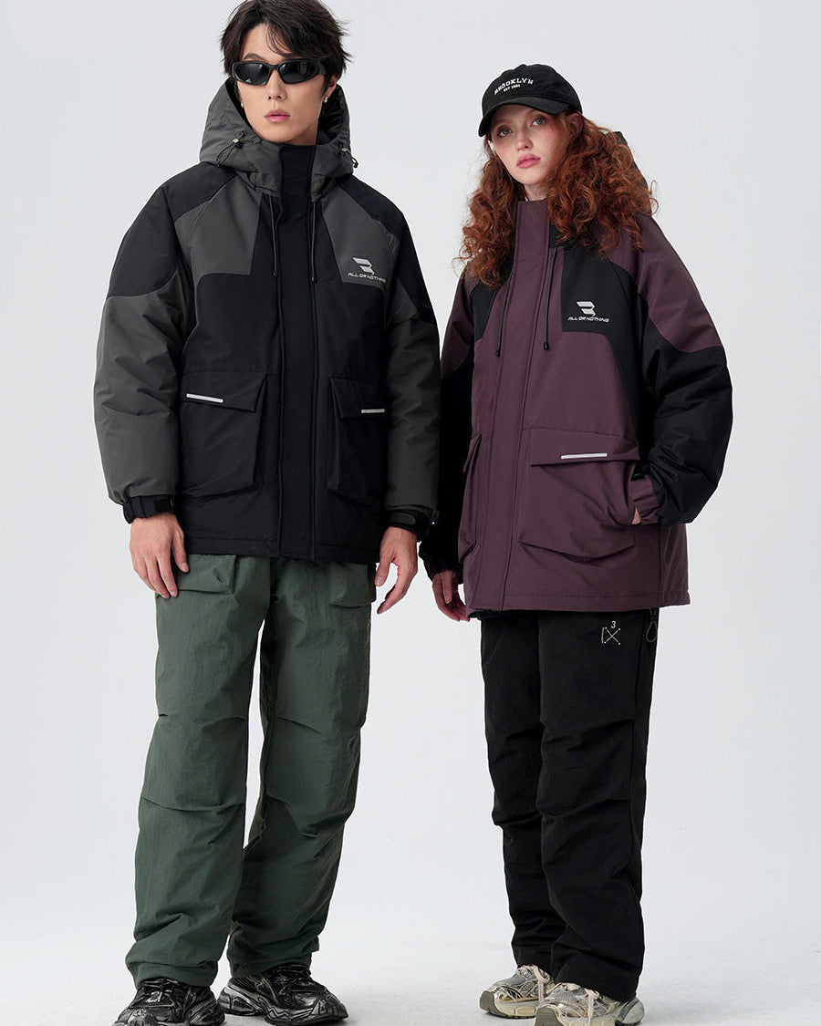 Two models standing together wearing All Drifting technical jackets - black with gray panels and plum with black panels on white background
