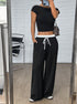 Mirror selfie of black wide-leg pants styled with crop top and leopard print bag