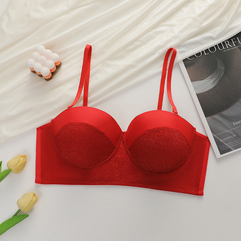 Flat lay of red sparkle bustier bra with adjustable straps, styled with yellow tulips and decorative elements