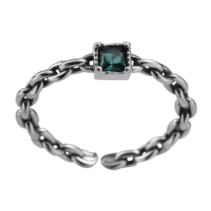 Silver chain link adjustable ring with square-cut emerald green gemstone in vintage-style setting, displayed against white background