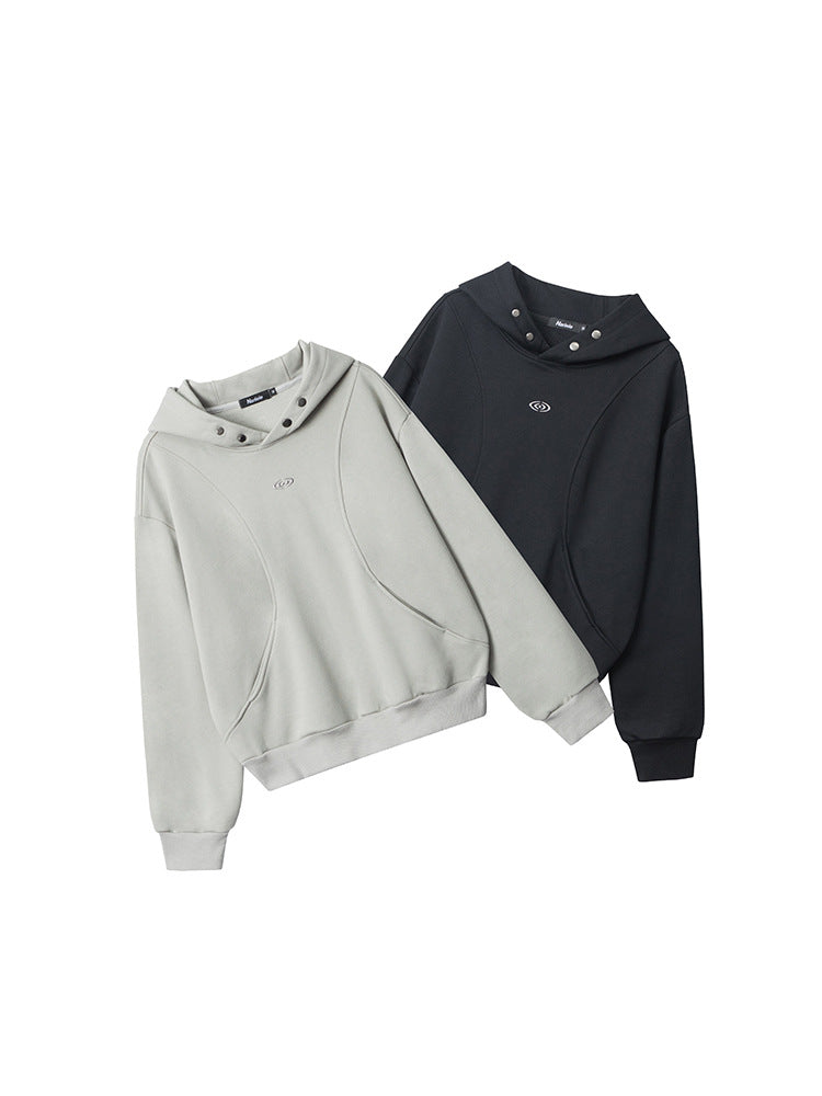 Two hooded sweatshirts displayed side by side - one in light gray and one in black, featuring snap-button hood details and embroidered logo on chest
