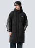 A man is posing at angle wearing black puffer coat with white stripe details against gray background. Features hood, front zip and shoulder backpack strap