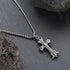 Close-up of silver cross pendant necklace on slate stone background