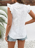 Back view of the white eyelet lace blouse, showing ruffled details and intricate floral embroidery, paired with light-wash denim shorts.