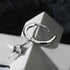 Single silver star drop hoop earring on geometric white surface, showing pendant detail