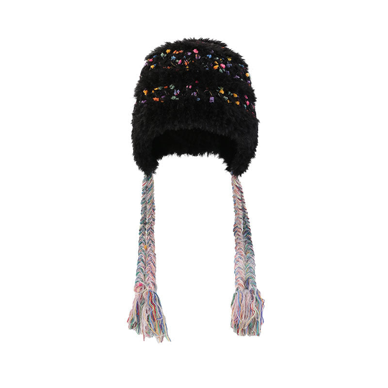 Detailed view of beige fuzzy winter hat with multicolored speckles, braided earflaps, and textured knit fabric