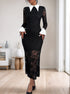 A woman in a fitted black lace dress with sheer lace sleeves, a white pointed collar, and trumpet cuffs, standing in a minimalist room.