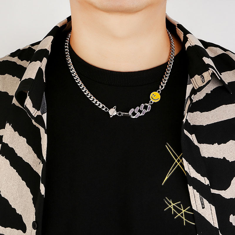 Titanium Steel Cuban chain necklace with yellow smiley charm and crystal snake accent styled on model wearing black t-shirt with striped jacket
