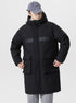 A man wearing black NEIGHBORHOOD parka with gray cap pulls pocket drawstrings while standing against white background in winter styling
