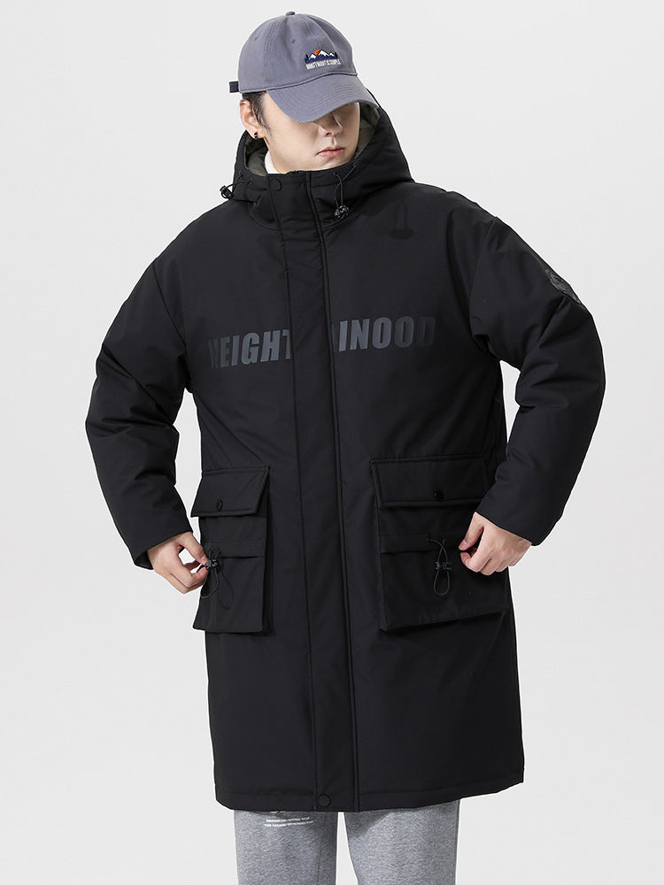 A man wearing black NEIGHBORHOOD parka with gray cap pulls pocket drawstrings while standing against white background in winter styling