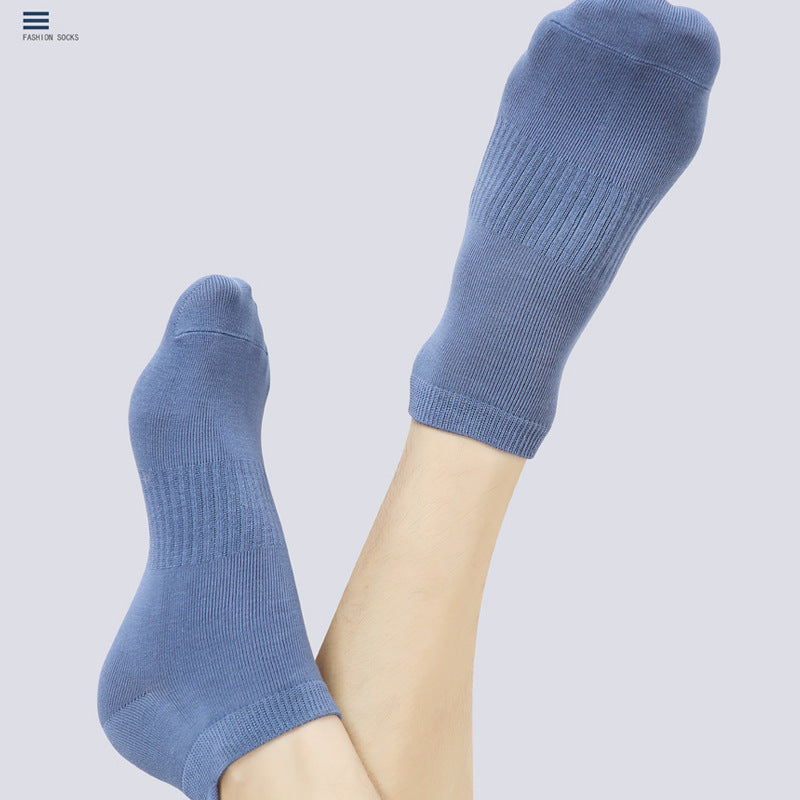 Close-up view of blue ankle socks on feet against light background. Features ribbed design with reinforced toe and heel areas with Fashion Socks branding