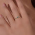 Close-up detail of gold eye ring with blue sapphire stone on a hand, showing natural skin texture