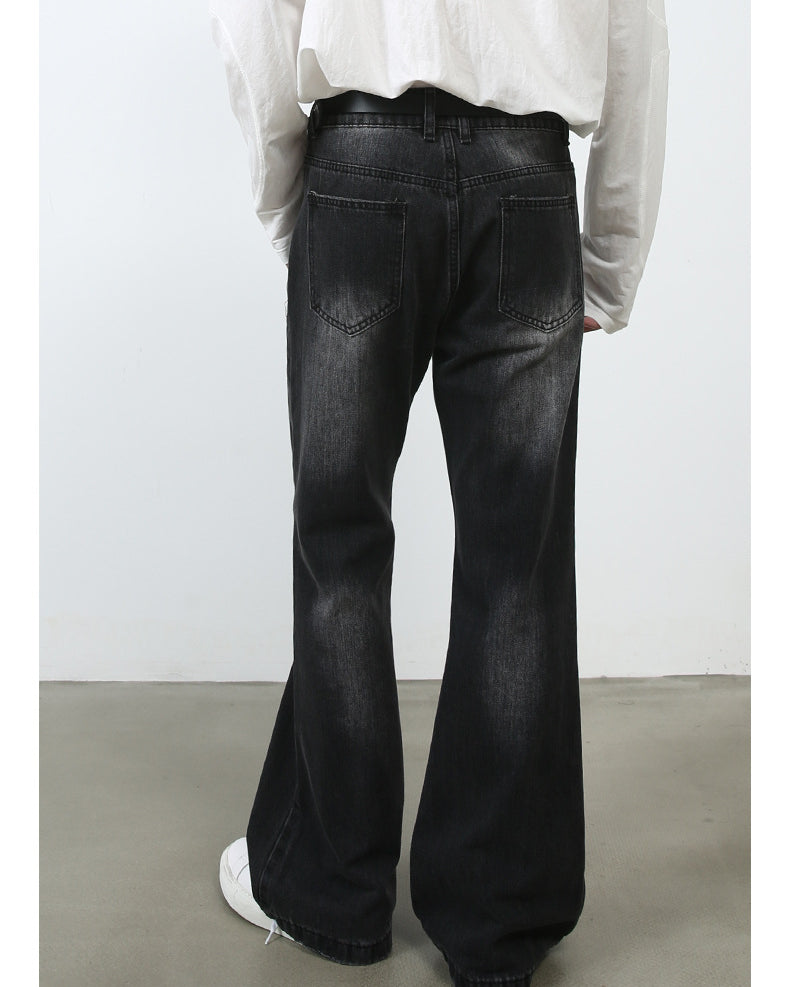 Back view of model wearing white button-up shirt with black washed wide-leg jeans and white sneakers on concrete floor