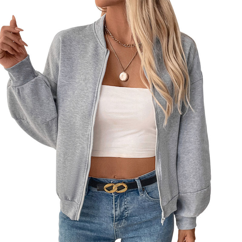 Gray zip-up jacket with white tube top, model wearing gold accessories