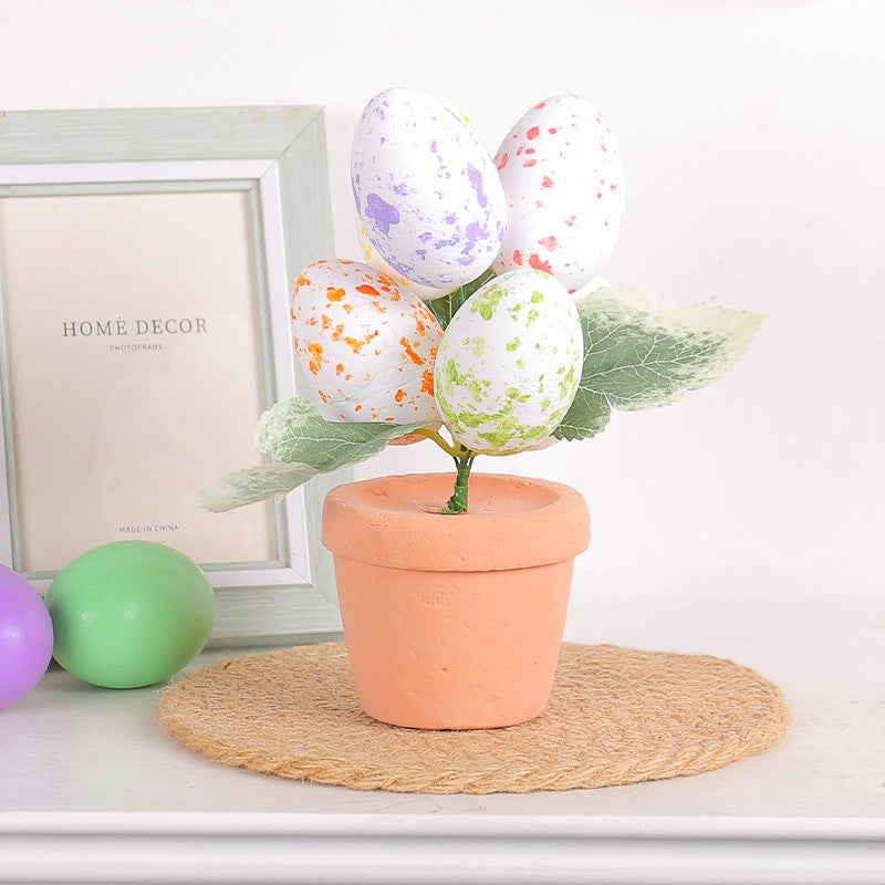 Single Easter egg tree with five speckled eggs in a terracotta pot, placed on a woven mat with decor and eggs in the background.