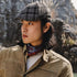 Fashion lifestyle photo showing small round stud earring in silver, worn with plaid cap and casual attire