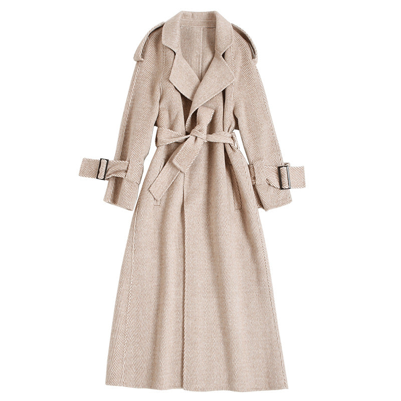 Flat lay of a beige wool trench coat with a belted waist and cuff straps
