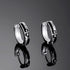 Product photo of stainless steel hoop earrings pair with black enamel inlay and fleur-de-lis design on dark background